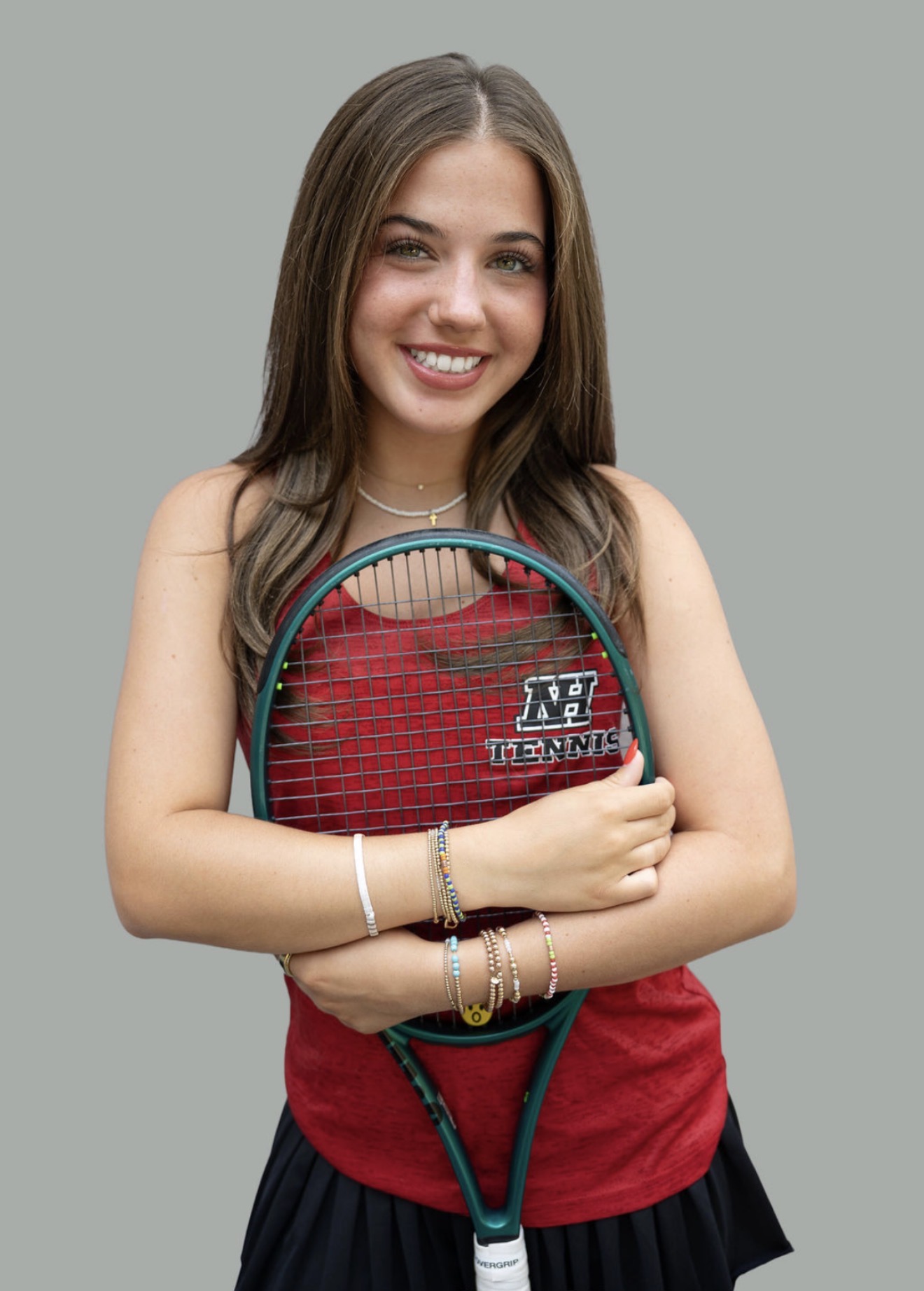 Tatum smiling and holding her tennis racket