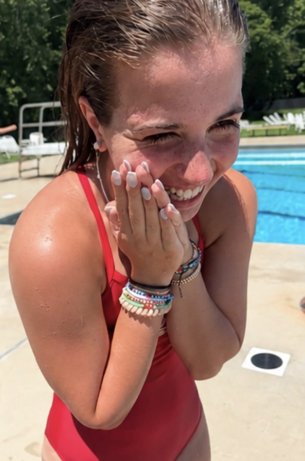 Tatum in her red lifeguard swimsuit laughing poolside at the Saddle River Valley Pool Club