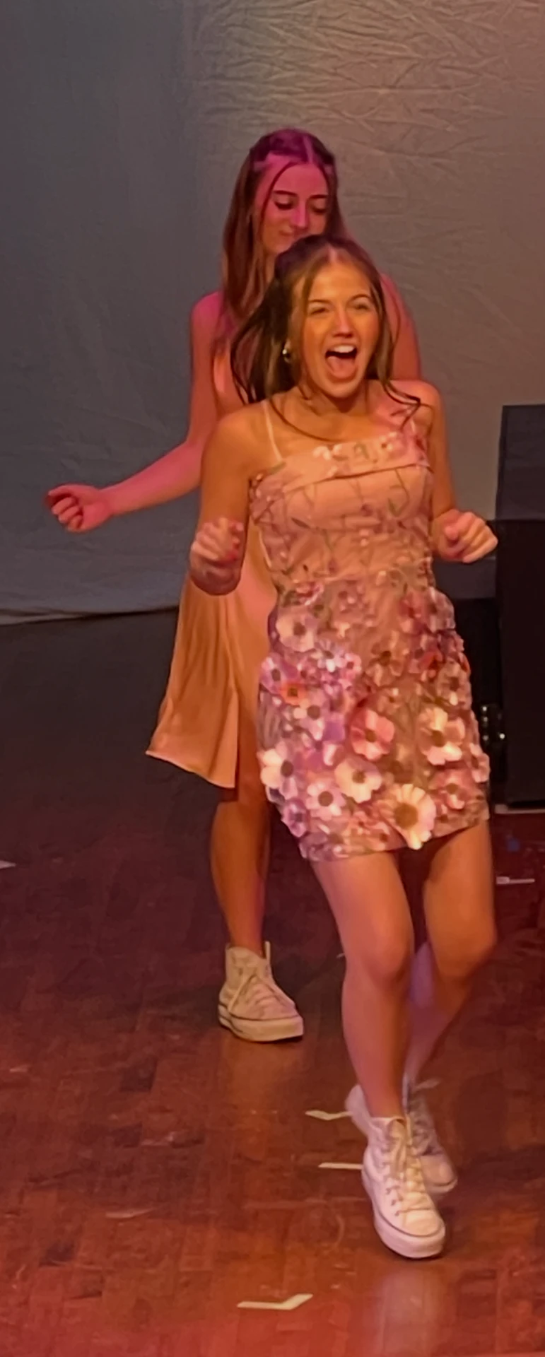 Tatum dancing on stage with a cast member, both in pink and peach dresses